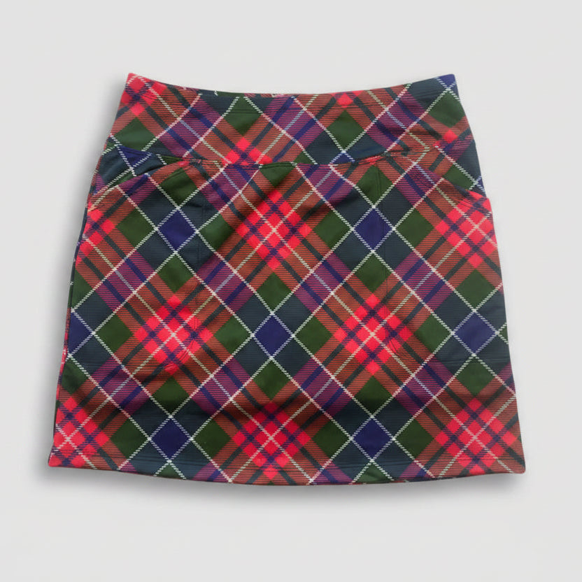 A high-waisted athletic mini skirt featuring a vibrant red, green, and navy tartan plaid pattern with thin white diagonal stripes, laid flat on a white background.