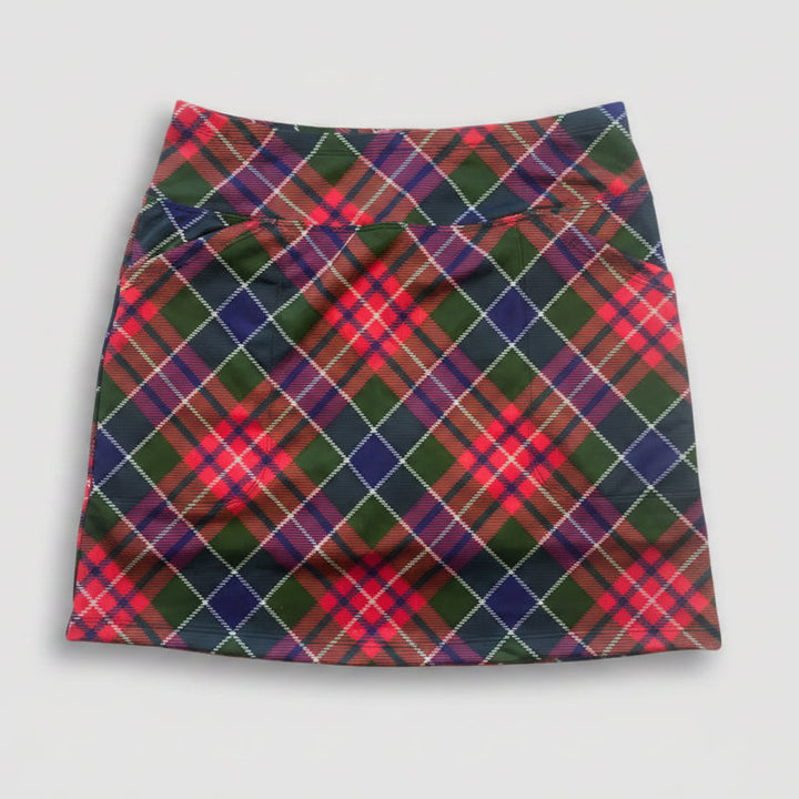 A high-waisted athletic mini skirt featuring a vibrant red, green, and navy tartan plaid pattern with thin white diagonal stripes, laid flat on a white background.