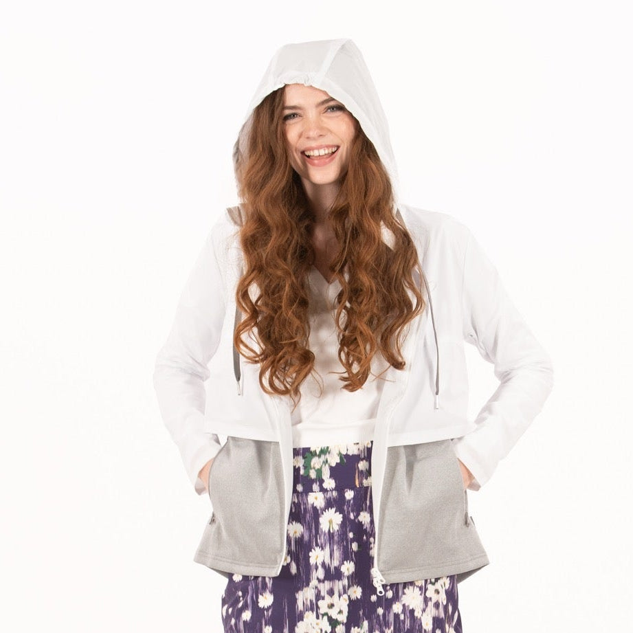 Woman wearing a white jacket, floral skirt, and black boots on a white background